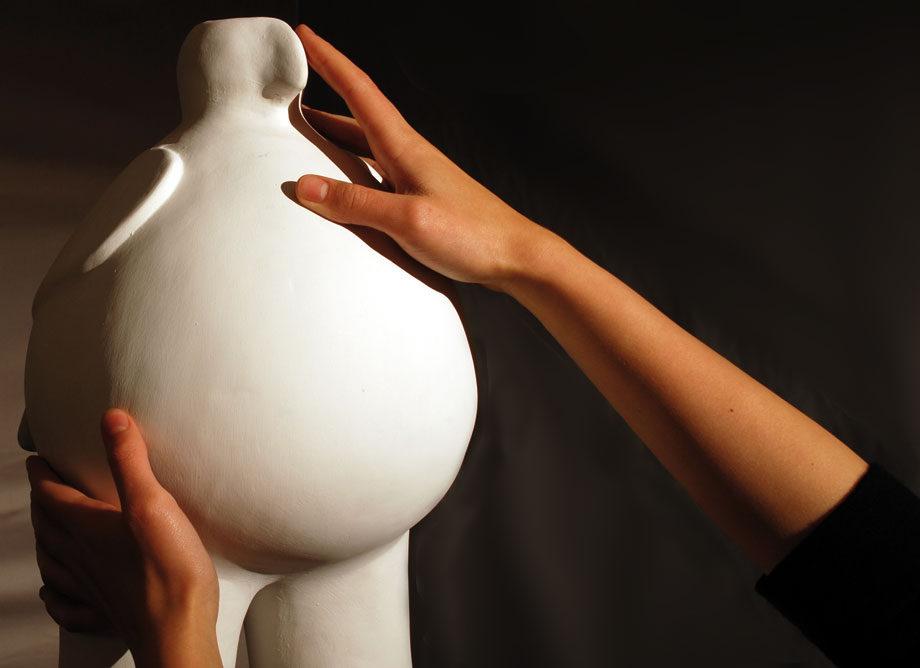 Manos de mujer tocando una de las réplicas exhibidas
